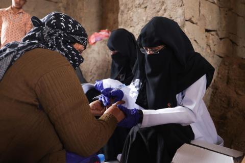 A health outreach team member provides health care services to a woman in Ta’iz. © IOM 2022/Majed Mohammed