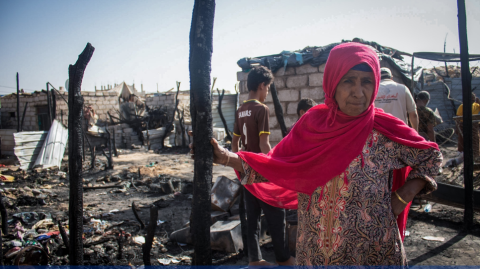 A displaced woman in sorrow next to what used to be her shelter after a fire broke out in Al Jufainah Camp © E. Al Oqabi/IOM 2021