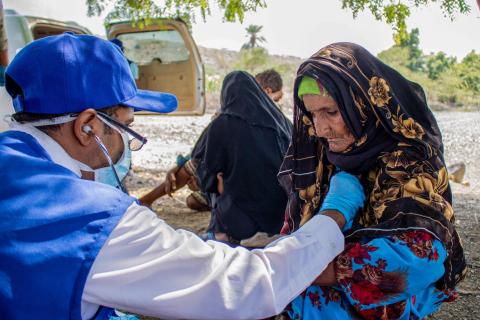 An IOM mobile medical team provides medical care to a displaced elderly woman in a remote location on the west coast of Yemen. © IOM 2021/ Rami Ibrahim 